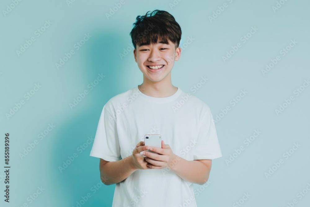 Young boy smiling while holding a cell phone, suitable for various social media and technology-related themes Young boy smiling while holding a cell phone, suitable for various social media and technology-related themes