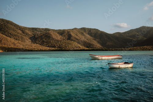 Two small Boats in the Carribean Sea with hills of the Parque Nacional Henri Pittier. Ocumare de la Costa, Venezuela - January 2024 photo