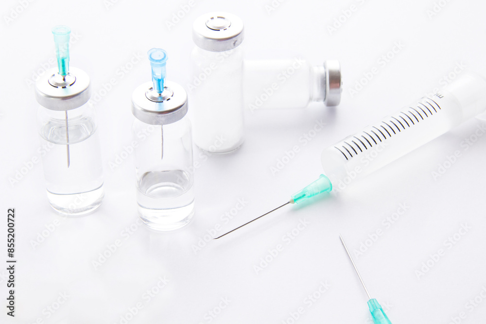 The syringe, needle, pills and medicine bottle on a light background The syringe, needle, pills and medicine bottle on a light background