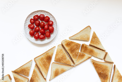 Foto Flat lay still life toasts arranged in corner and cherry tomatoes on white plate