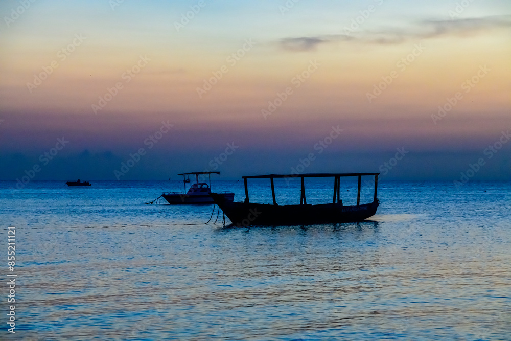 Traditional tourist boats at the Indian ocean when sunset. Zanzibar, Tanzania Traditional tourist boats at the Indian ocean when sunset. Zanzibar, Tanzania