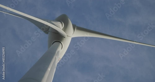 Wind turbine windmill turning in a blue sky with clouds