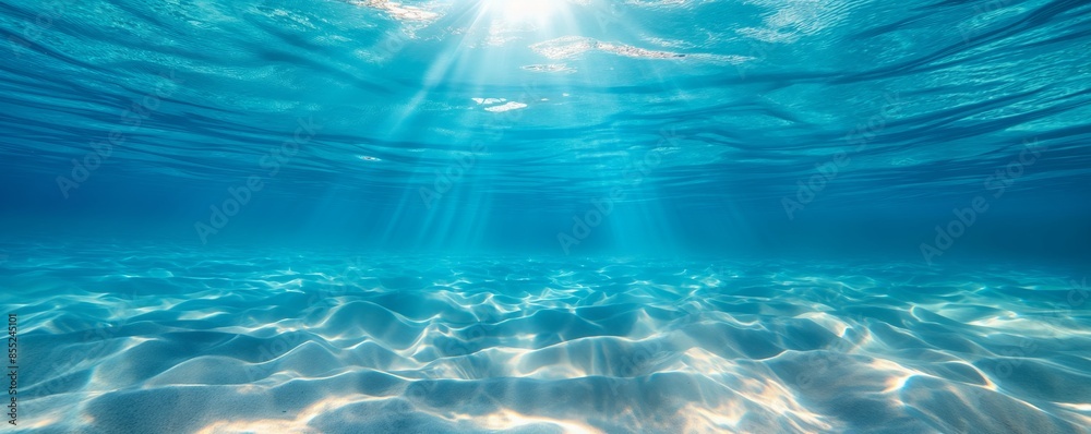 Peaceful underwater scene with light rays streaking across the sandy ocean floor Peaceful underwater scene with light rays streaking across the sandy ocean floor