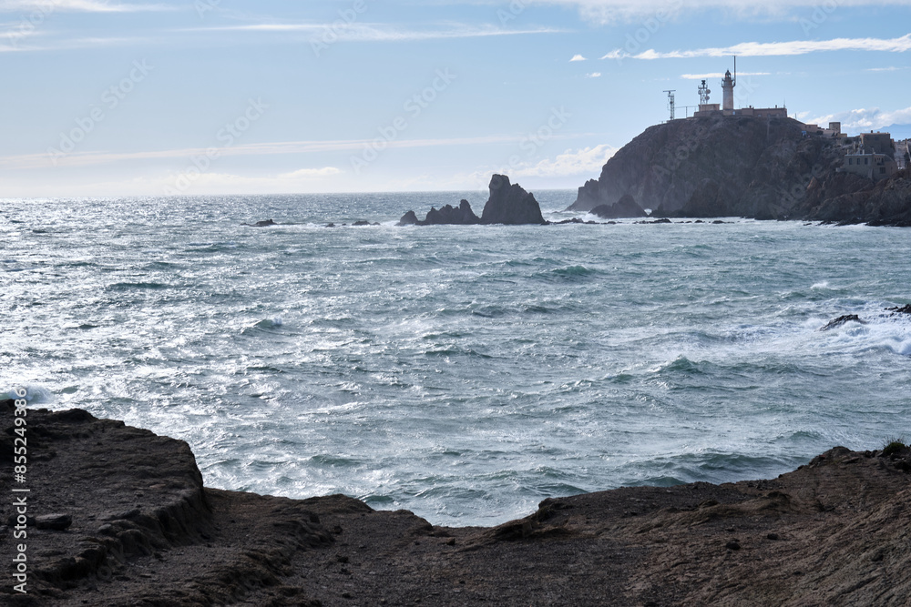 View of the coast and the lighthouse of El Arrecife De Las Sirenas in Cabo De Gata, Almeria, Spain. View of the coast and the lighthouse of El Arrecife De Las Sirenas in Cabo De Gata, Almeria, Spain.