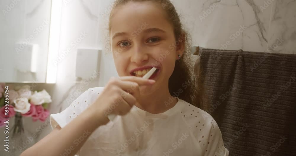 Portrait caucasian child cute kid brushing looking at mirror at home. Healthcare Lifestyle. Portrait happy cute young child brushing teeth in bathroom and smiling. Baby daily healthcare routine. 4K Portrait caucasian child cute kid brushing looking at mirror at home. Healthcare Lifestyle. Portrait happy cute young child brushing teeth in bathroom and smiling. Baby daily healthcare routine. 4K