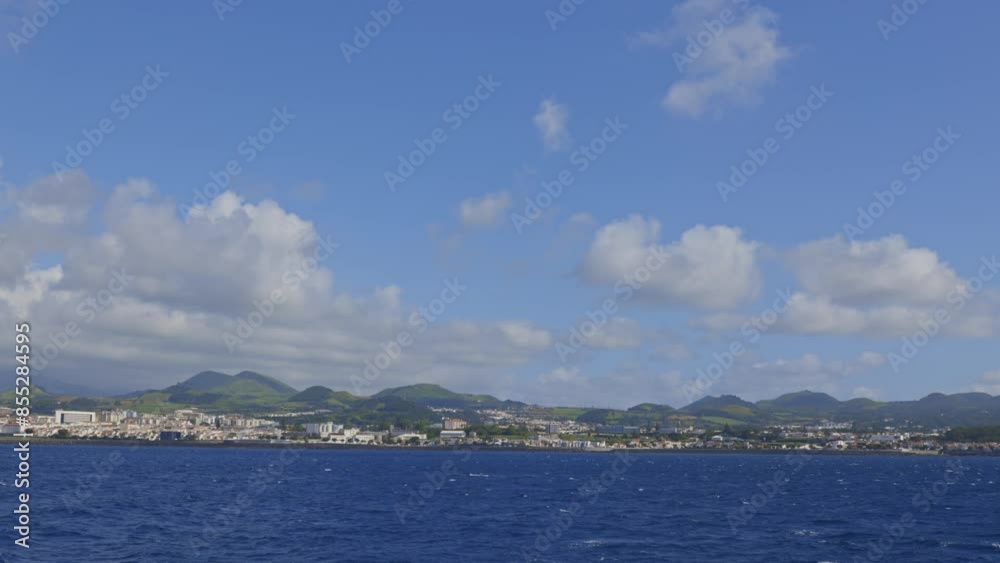 Azores islands - beautiful blue sky with a few clouds and a city in the background Azores islands - beautiful blue sky with a few clouds and a city in the background