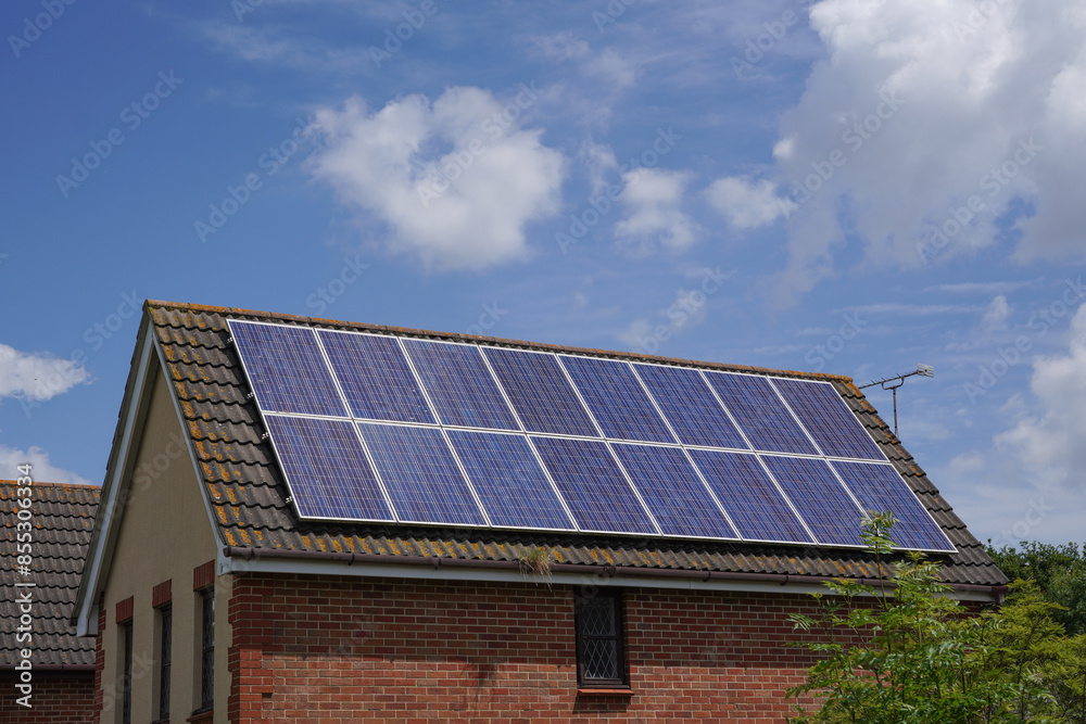 Naklejka premium solar panels installed on roof of residential property. photovoltaic solar cells on rooftop. power and eco energy source 