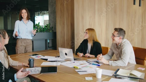 A team is gathering in a contemporary office space to engage in discussions about project strategies, prioritizing collaboration, innovation, and teamwork for achieving business prosperity