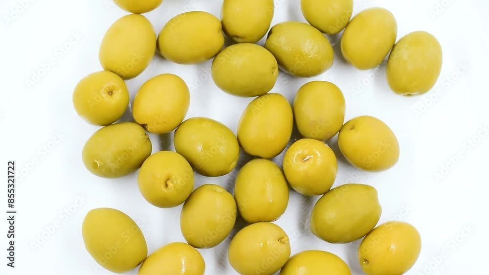 Pile of Italian whole green olives on white plate,fruit view directly above,close-up,rotating video. Pile of Italian whole green olives on white plate,fruit view directly above,close-up,rotating video.