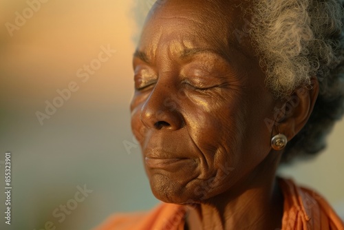 Senior black woman enjoying golden hour light with eyes closed