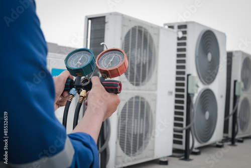 Technician is checking air conditioner,measuring equipment for filling air conditioners.