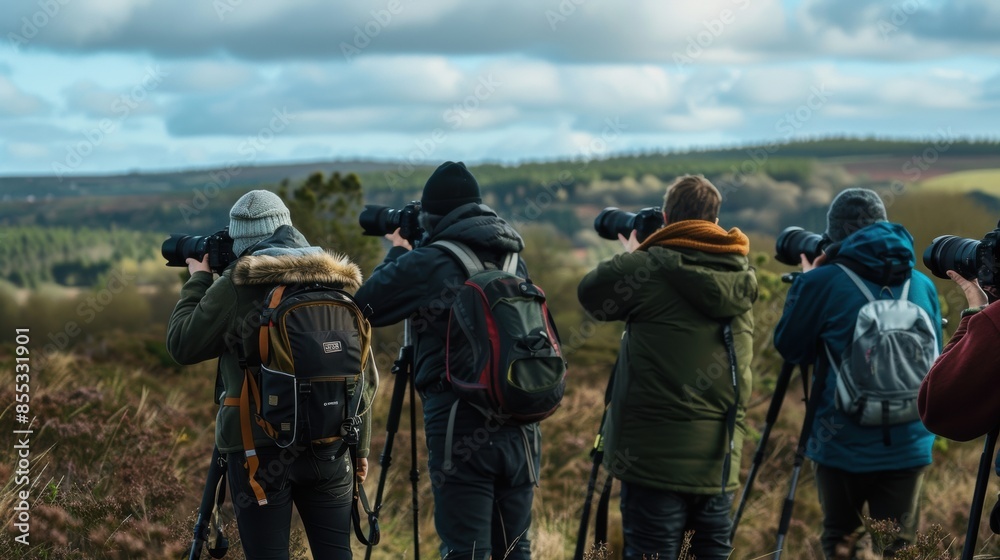 Several photographers with various cameras are shooting something in the distance in a nature. Several photographers with various cameras are shooting something in the distance in a nature.
