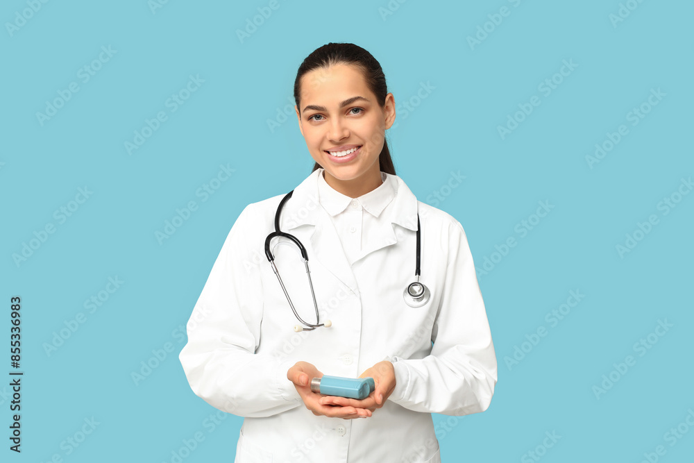 Portrait of female doctor with inhaler on blue background Portrait of female doctor with inhaler on blue background