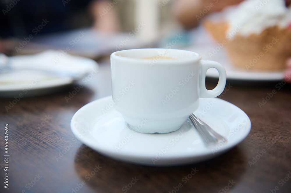 Close-up of coffee cup on wooden table in a cafe Close-up of coffee cup on wooden table in a cafe