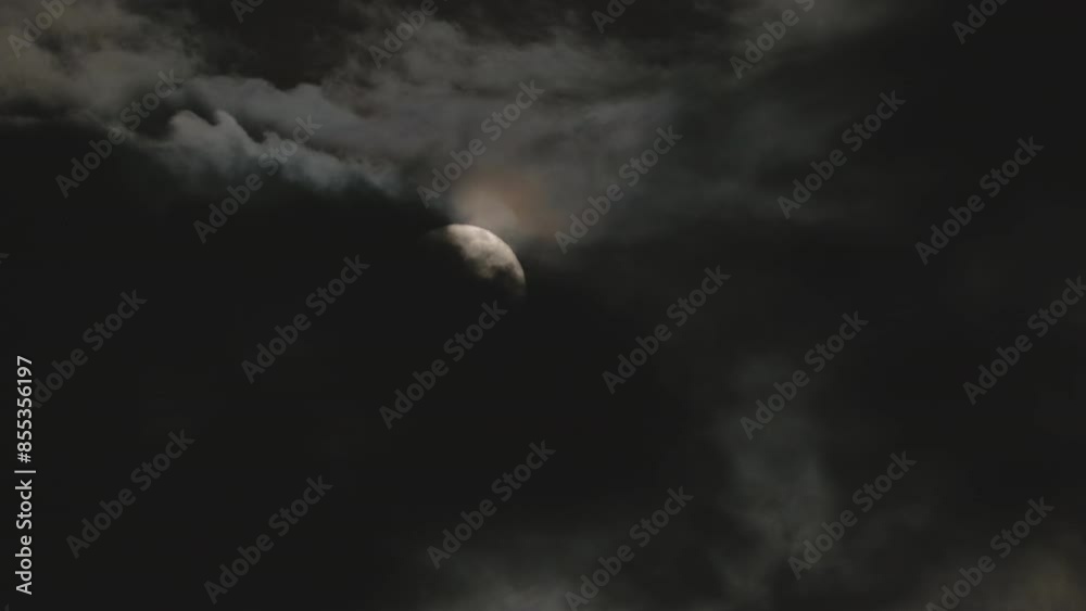 Night cloudy sky with black clouds and full moon. Gloomy night skyscape in the moonlight. Midnight on Halloween, real video footage