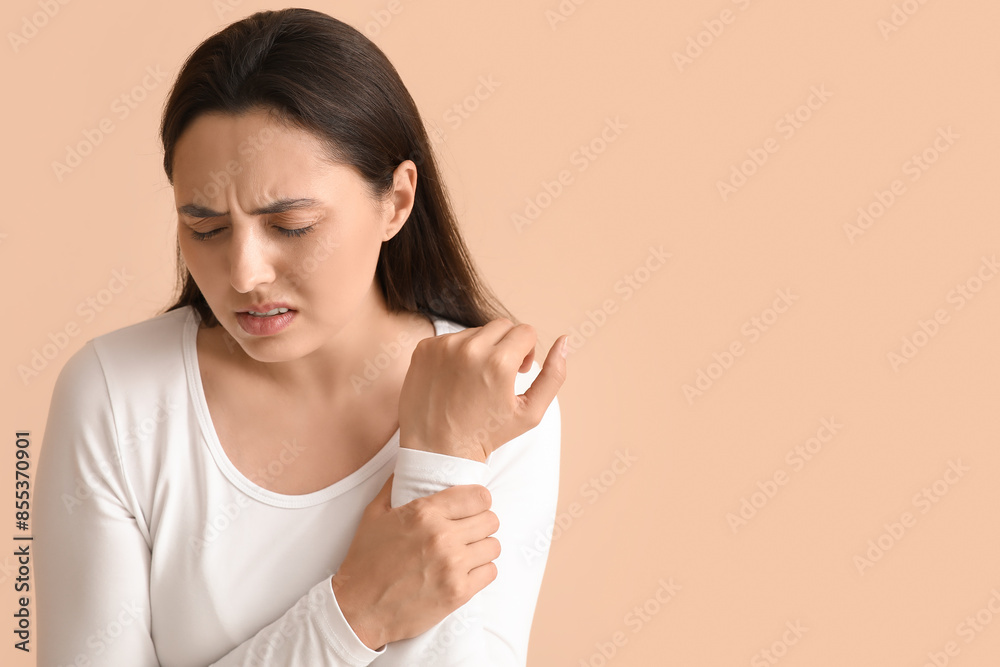 Young woman suffering from pain in wrist on beige background, closeup Young woman suffering from pain in wrist on beige background, closeup