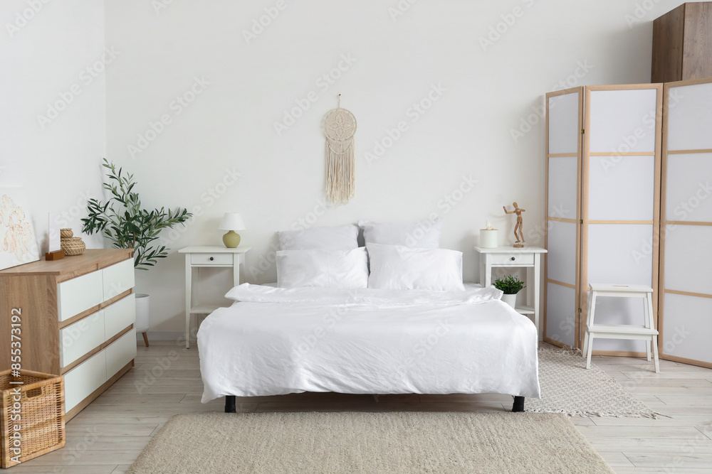 Interior of light bedroom with big bed, tables and commode Interior of light bedroom with big bed, tables and commode