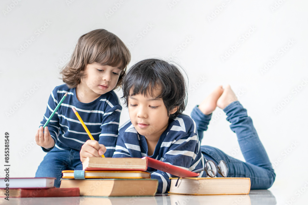 Education and back to school concept. Portrait of Two Happy little child boy learning and reading a book on the floor. Preschool children kids enjoy and fun study and doing homework at home.