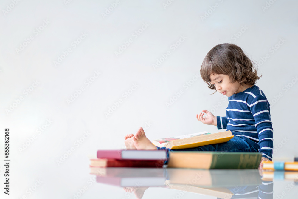 Education and back to school concept. Portrait of Happy little kindergarten child boy learning to read a book on the floor. Preschool children kids enjoy and fun study and doing homework at home.