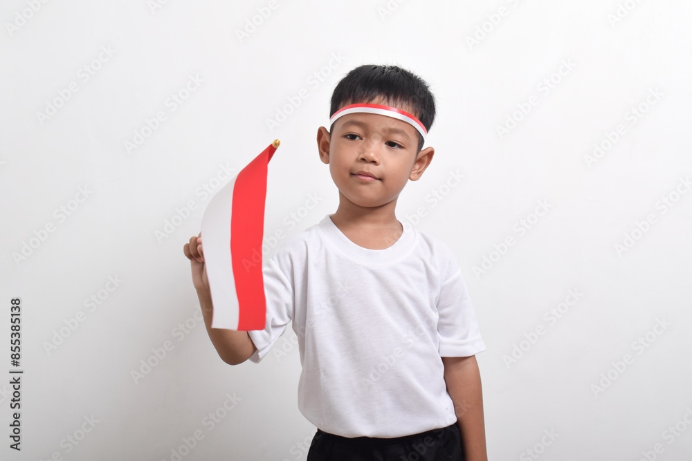 Cute little Asian boy holding Indonesia's flag to celebrate Indonesia Independence Day isolated on white background. Cute little Asian boy holding Indonesia's flag to celebrate Indonesia Independence Day isolated on white background.