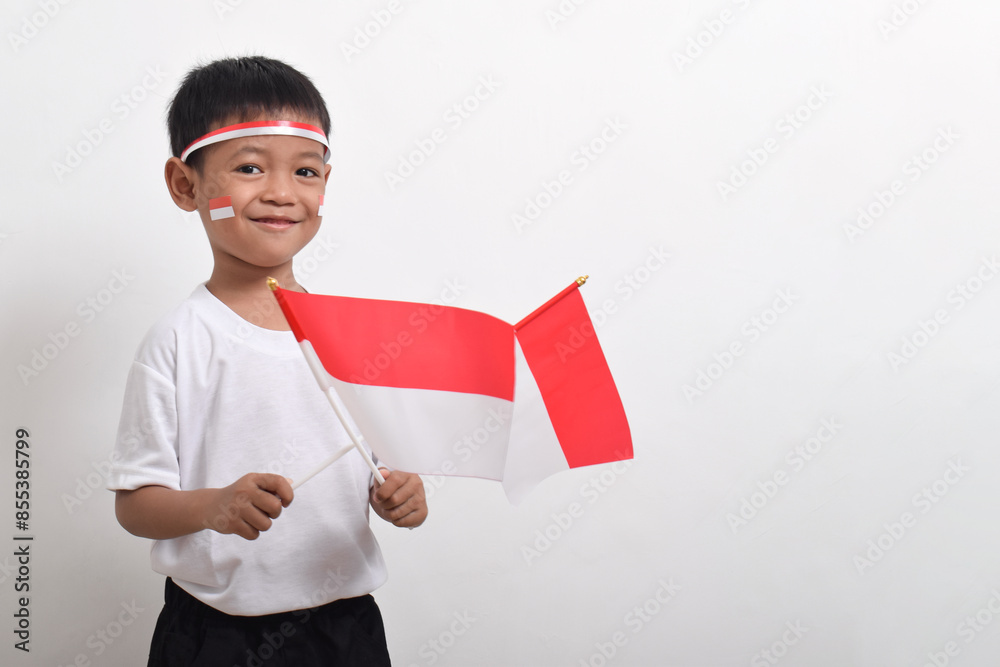 Cute little Asian boy holding Indonesia's flag to celebrate Indonesia Independence Day on August 17 isolated on white background. Cute little Asian boy holding Indonesia's flag to celebrate Indonesia Independence Day on August 17 isolated on white background.