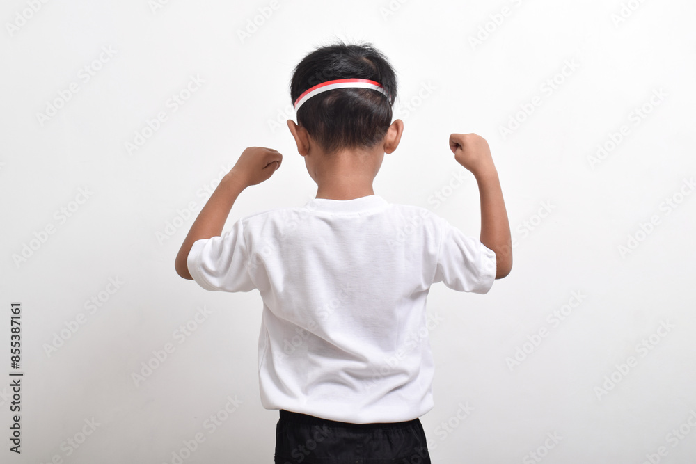 Back view of cute little Asian boy with happy success attitude wearing flag headband isolated on white background. Indonesia's independence day concept. Back view of cute little Asian boy with happy success attitude wearing flag headband isolated on white background. Indonesia's independence day concept.