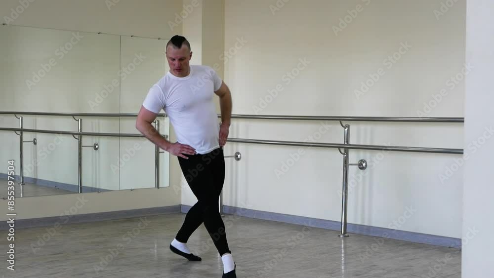 A ballerina dancer warms up on a ballet barre. A man in ballet shoes is rehearsing in the hall. Professional classical ballet, warming up during training. A ballerina dancer warms up on a ballet barre. A man in ballet shoes is rehearsing in the hall. Professional classical ballet, warming up during training.