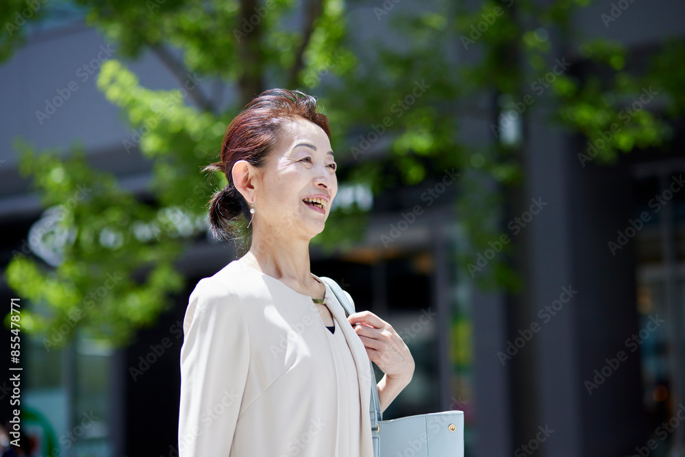 春のオフィス街で働くシニア女性社長 春のオフィス街で働くシニア女性社長