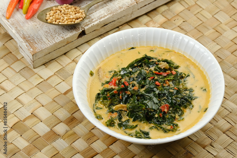 Gulai Daun Singkong or Cassava leaf curry with coconut milk, turmeric, tomatoes, chili and other seasonings and herb. Indonesian food, recipe and cuisine Gulai Daun Singkong or Cassava leaf curry with coconut milk, turmeric, tomatoes, chili and other seasonings and herb. Indonesian food, recipe and cuisine
