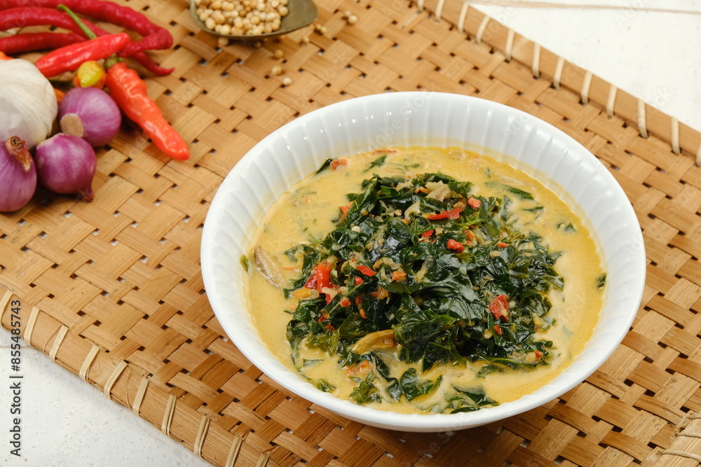 Gulai Daun Singkong or Cassava leaf curry with coconut milk, turmeric, tomatoes, chili and other seasonings and herb. Indonesian food, recipe and cuisine Gulai Daun Singkong or Cassava leaf curry with coconut milk, turmeric, tomatoes, chili and other seasonings and herb. Indonesian food, recipe and cuisine