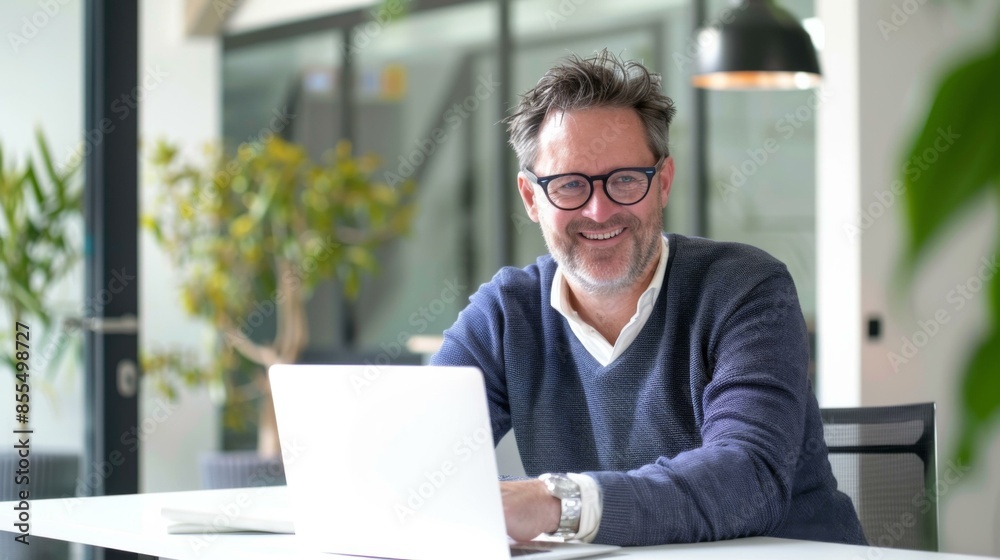 A man smiles while using his laptop. AI. A man smiles while using his laptop. AI.