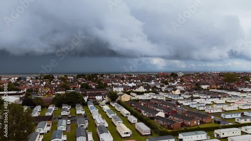 Looming storm over the seaside town of Skegness. English Holiday reasort showing caravan sites and hotels with stormy sky’s over the ocean. British Coastal scene with bad summer weather. photo