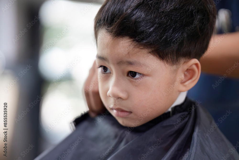 Asian boy Getting a haircut at the barber shop Asian boy Getting a haircut at the barber shop