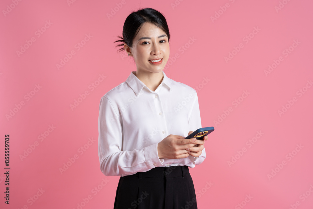 Portrait of beautiful Asian female businessman posing on pink background Portrait of beautiful Asian female businessman posing on pink background