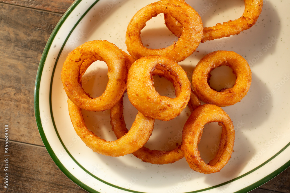 A top down view of a plate of onion rings. A top down view of a plate of onion rings.