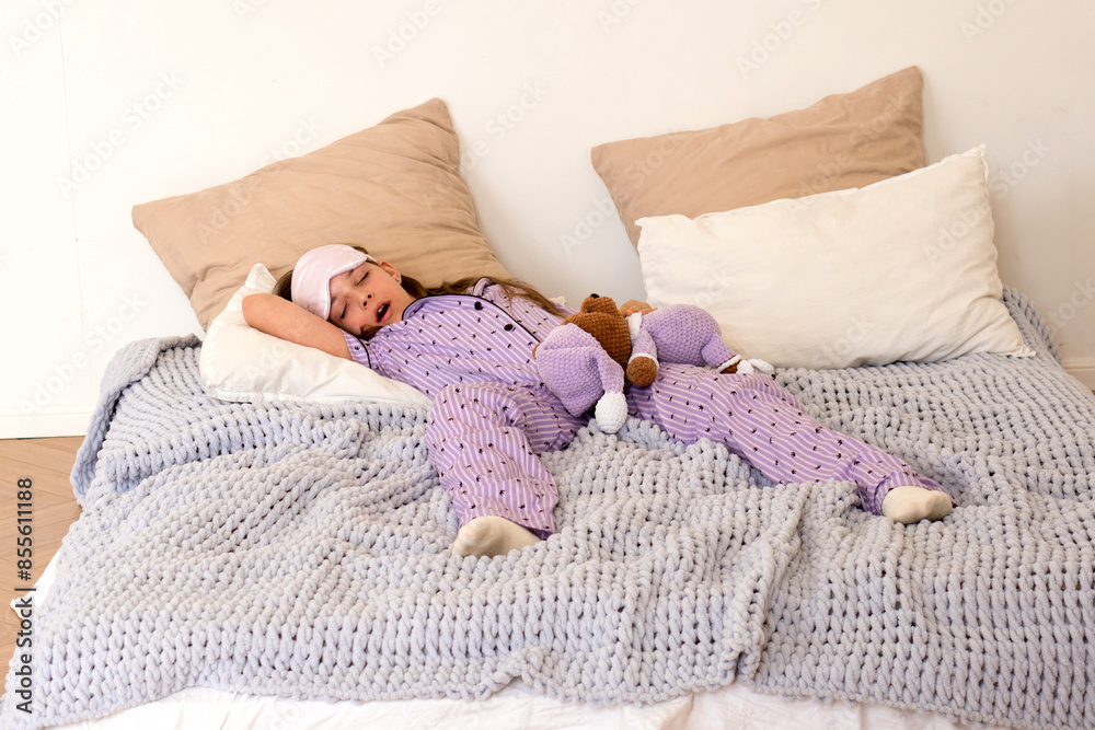 Girl napping in bed with teddy bear in purple pajamas. Girl napping in bed with teddy bear in purple pajamas.