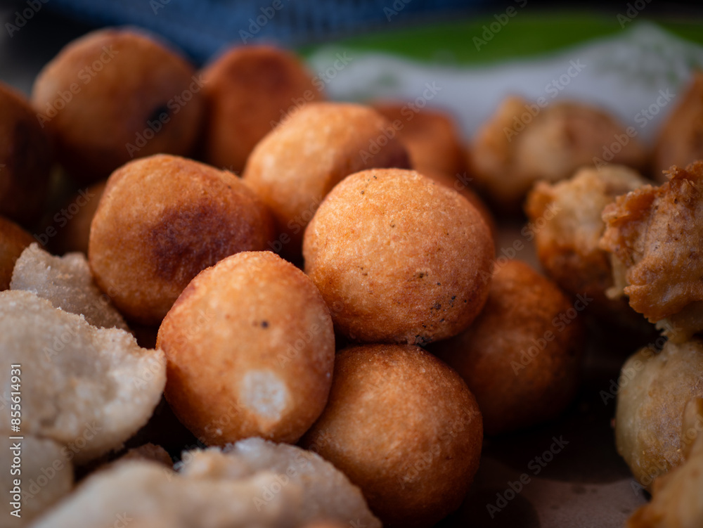 Jemblem. Indonesian traditional food is sweet and savory. It's made of grated cassava with melted brown sugar as filling. The food is deep fried. Selective focus Jemblem. Indonesian traditional food is sweet and savory. It's made of grated cassava with melted brown sugar as filling. The food is deep fried. Selective focus