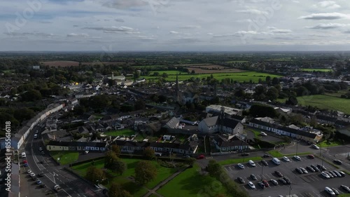 Kells, County Meath, Ireland, October 2023. Drone at a higher angle orbits while pushing towards St Columba's Church of Ireland and Kells Round Tower on a clear day. photo