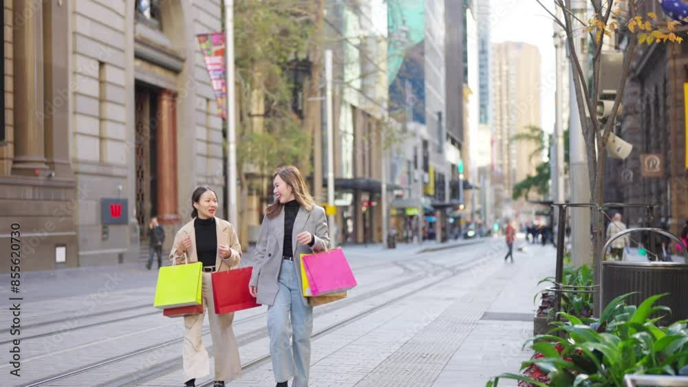 Happy Asian woman shopping in the city. Women friends holding shopping bag walking together at city street. People enjoy and fun urban outdoor lifestyle travel city street on holiday vacation. Happy Asian woman shopping in the city. Women friends holding shopping bag walking together at city street. People enjoy and fun urban outdoor lifestyle travel city street on holiday vacation.