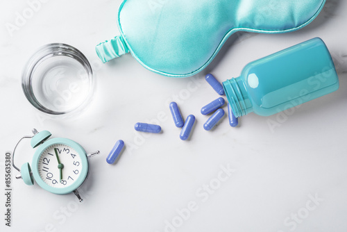 Cuadro en lienzo Sleeping pill and glass of water, eye mask, alarm clock on white table backgroun