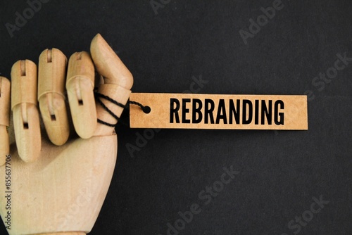 hand holding a paper tag with the word REBRANDING photo