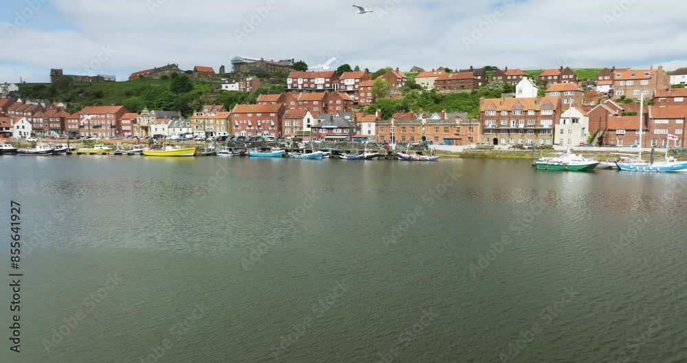 Waterfront Architectures And Mooring Boats At Whitby Town In Yorkshire, Northern England, United Kingdom. Panning Shot Waterfront Architectures And Mooring Boats At Whitby Town In Yorkshire, Northern England, United Kingdom. Panning Shot