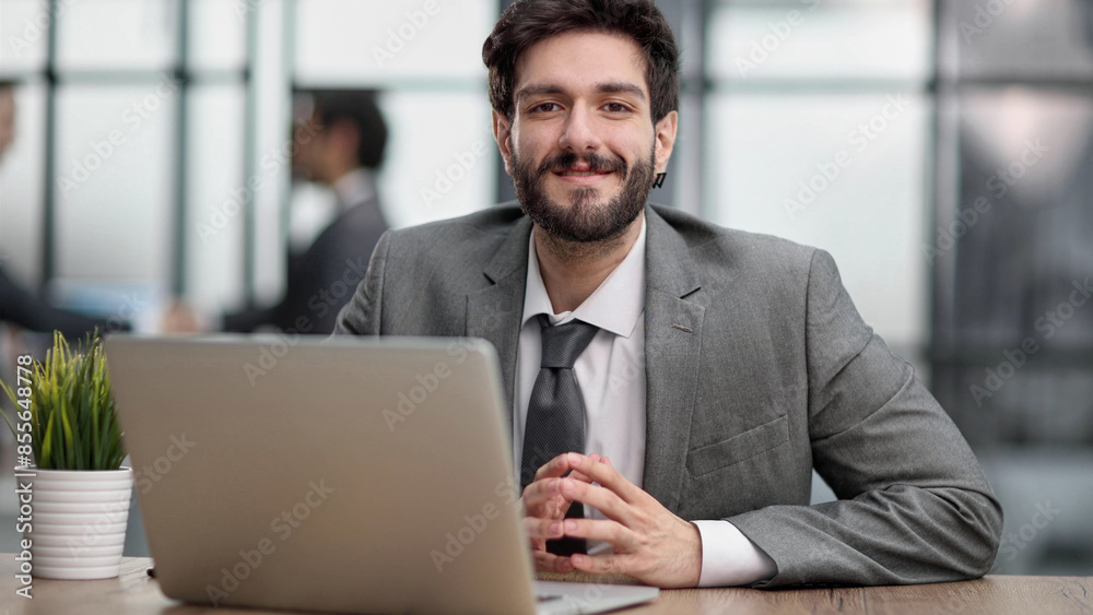 portrait of a young businessman working on laptop in the office portrait of a young businessman working on laptop in the office