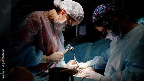 Dedicated surgeon with team of medical assistants meticulously operates on patient. High-tech surgical suite surgeon leads complex operation with support of skilled assistants surgical interventions.
