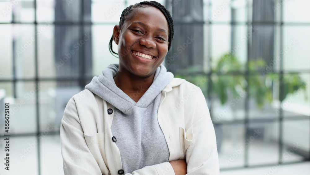 Smiling young woman standing and looking at the camera.