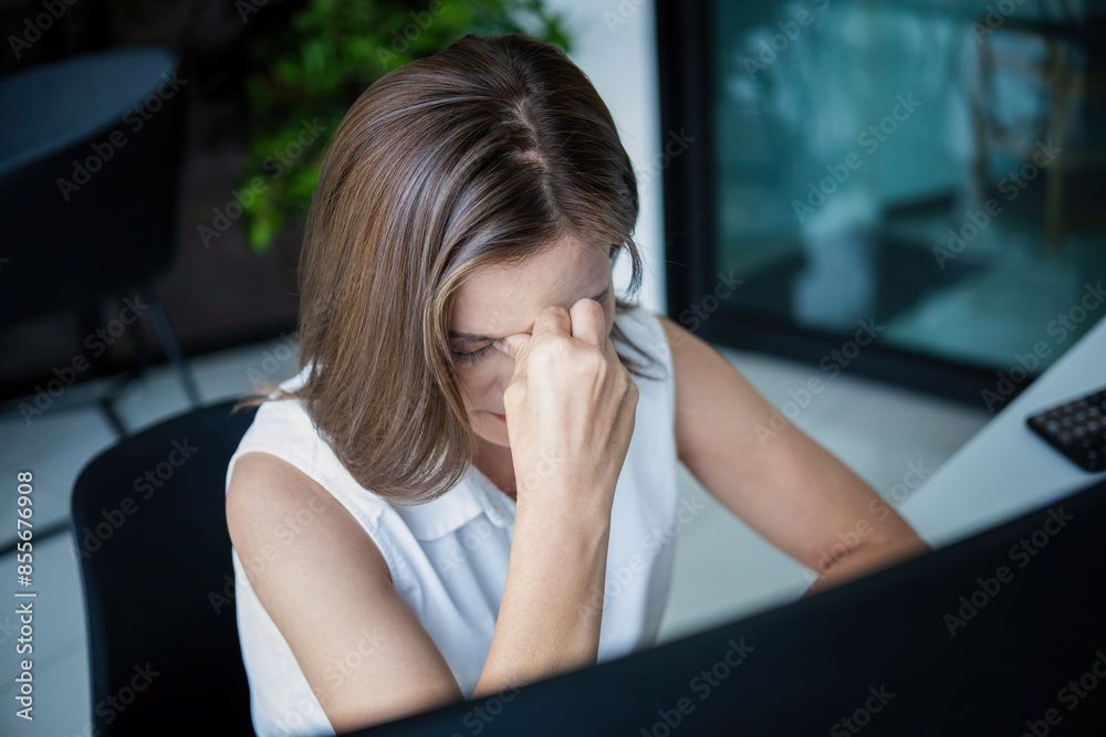 Businesswoman sitting at desk on couch in workplace or at home working on laptop and analyzing data on charts and graphs and writing on papers to make business plan and strategies for company, startup Businesswoman sitting at desk on couch in workplace or at home working on laptop and analyzing data on charts and graphs and writing on papers to make business plan and strategies for company, startup