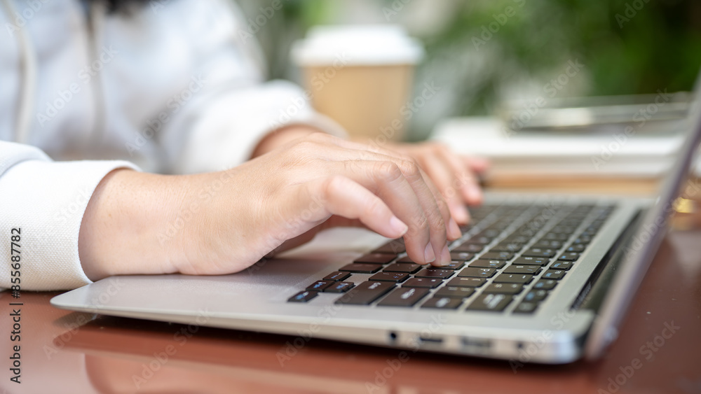A close-up image of a woman working on her laptop computer, typing on the laptop keyboard. A close-up image of a woman working on her laptop computer, typing on the laptop keyboard.