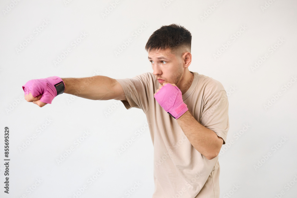 Young man tied pink boxing bandages before training Young man tied pink boxing bandages before training