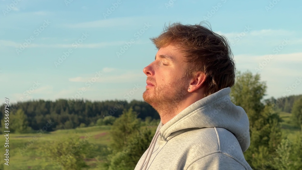 Young man enjoying nature at summer day in the park or forest, deep breath fresh air Young man enjoying nature at summer day in the park or forest, deep breath fresh air