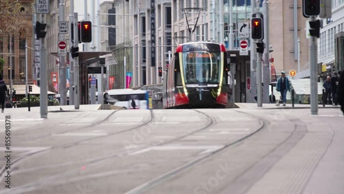 Timelapse of busy crowded pedestrian man and woman business people and tourist walking street crosswalk with traffic on the road and moving tram on tramway tracks at Sydney, Australia.